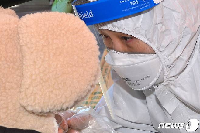 19일 경북 포항시 남구 시민운동장에 마련된 신종 코로나바이러스 감염증(코로나19)선별진료소에서 어린이가 검체 검사를 받고 있다. 2021.12.19/뉴스1 © News1 최창호 기자