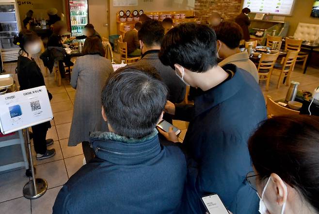 ‘방역패스’(접종증명·음성확인제)‘ 의무화가 확대된 지난 13일 광주 북구 모 식당에서 손님들이 코로나19 예방 백신 접종 인증 절차를 준비하고 있다. 사진은 해당 기사 내용과 무관. (사진=뉴시스)