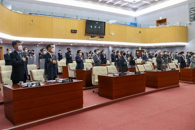 제11대 전북도의회 의원들이 본회의장에서 국민의례를 하고 있다.