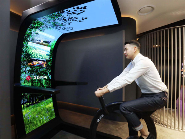 LG디스플레이 직원이 OLED 스크린과 운동기구를 합친 콘셉트 제품 `버추얼 라이드`를 체험하고 있다. [사진 출처 = LG디스플레이]