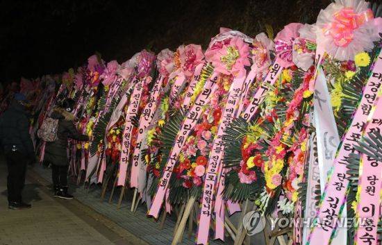 30일 밤 서울 강남구 일원동 삼성서울병원 앞에 박근혜 전 대통령 지지자들이 보낸 박 전 대통령 쾌유 기원 화환이 놓여 있다. [이미지출처=연합뉴스]