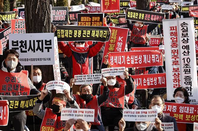 지난 8일 오후 국회 인근에서 열린 '코로나 피해 실질 보상 촉구 정부 여당 규탄대회'에서 코로나 피해 자영업 총연합 회원들이 실질적인 손실보상 및 집합제한 명령 전면 해제 등을 촉구하는 내용의 손 피켓을 들고 있다. ⓒ연합뉴스