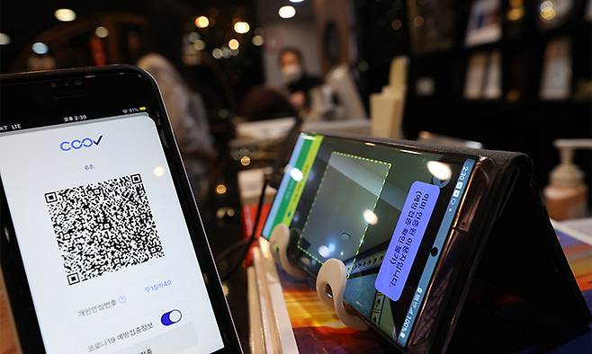 방역패스(접종증명·음성확인제)에도 6개월 유효기간이 적용된 3일 서울 종로구 음식점에서 한 미접종 시민이 QR 체크인을 하고 있다. 연합뉴스