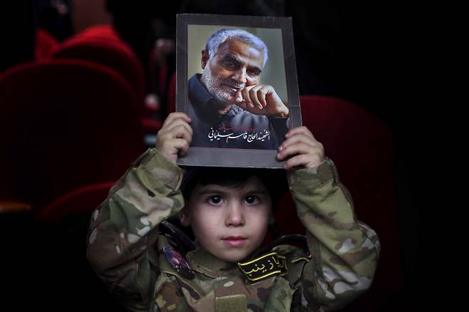 “순교자 솔레이마니” 3일(현지시간) 군복을 입은 한 레바논 소년이 가셈 솔레이마니 이란 혁명수비대 쿠드스군 사령관의 사진을 들고 그를 추모하고 있다. 이날 이란, 이라크, 레바논 등지에서는 도널드 트럼프 미국 정권의 드론 공습으로 사망한 솔레이마니의 2주기 추모 행사가 열렸다.    다히예 | AP연합뉴스
