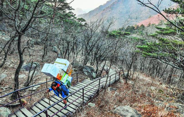 "힘들게 번 돈 나한테 쓰면 아깝더라." '설악산 마지막 지게꾼' 임기종씨가 지난달 21일 설악산 흔들바위 옆으로 짐을 옮기고 있다. 그는 지게꾼 일과 막노동으로 번 생활비의 대부분을 불우이웃돕기에 쓰고 있다.