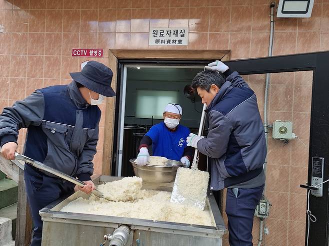 해창주조장 직원들이 고두밥을 발효탱크로 옮겨담고 있다. 이 양조장은 고두밥을 식힌 뒤에 다시한번 찬물로 씻어 막걸리의 텁텁한 맛을 없앤다. /박순욱 기자