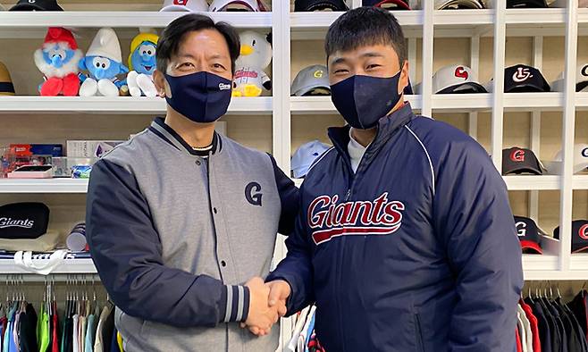 정훈(오른쪽)이 5일 롯데와 FA 계약을 체결한 뒤 이석환 대표이사와 악수하고 있다. 롯데 자이언츠 제공