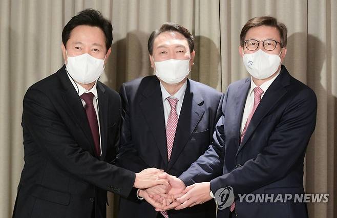 오세훈 서울시장, 박형준 부산시장과 악수하는 윤석열 후보 (서울=연합뉴스) 국민의힘 윤석열 대선 후보(가운데)가 5일 서울 강서구 메이필드호텔에서 오세훈 서울시장(왼쪽)과 박형준 부산시장을 만나 악수를 나누고 있다. 2022.1.5 [국회사진기자단] toadboy@yna.co.kr