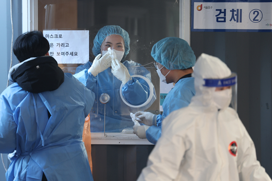 6일 오전 서울역 코로나19 임시 선별검사소에서 의료진이 유리벽에 붙은 얼음 조각을 긁어내고 있다. 〈사진=연합뉴스〉