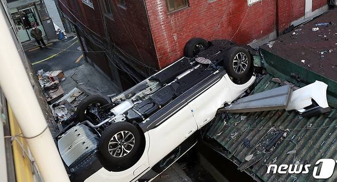 6일 오전 8시 30분께 서울 중구 숭례문 인근에 있는 한 민영 주차장에서 차량 1대가 야외로 추락해 지붕에 걸쳐져 있다.  2022.1.6/뉴스1 © News1 김명섭 기자