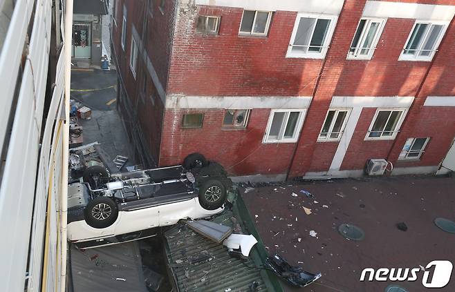 6일 오전 8시 30분께 서울 중구 숭례문 인근에 있는 한 민영 주차장에서 차량 1대가 야외로 추락해 지붕에 걸쳐져 있다. 소방 등에 따르면 스포츠유틸리티차(SUV) 1대가 약 3층 규모의 주차장 건물에서 추락해 인근 건물의 지붕을 덮쳤고 또 다른 승용차 1대도 추락할 뻔했으나 건물 밖으로 걸쳐져 추가 사고를 피했다고 밝혔다. 추락한 차량 내부에 사람은 없었고 다른 인명피해도 없는 것으로 알려졌다. 2022.1.6/뉴스1 © News1 김명섭 기자