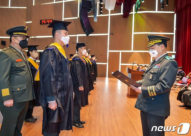 정해일 국방대 총장(오른쪽)이 6일 충남 논산 국방대학교에서 열린 2021학년도 학위수여식에 참석, 이민호 육군 대위에게 국방부장관상을 수여하고 있다. (국방부 제공) 2022.1.6/뉴스1