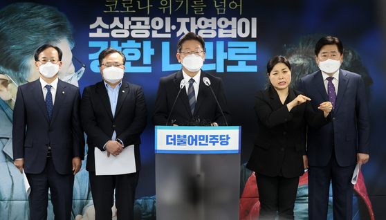 Flanked by his campaign staff, ruling Democratic Party (DP) presidential candidate Lee Jae-myung, former Gyeonggi governor, proposes ambitious plans to help small merchants and the self-employed, including issuing local currencies and coupons worth 50 trillion won ($41.7 billion) for the entire population, in December. [LIM HYUN-DONG]
