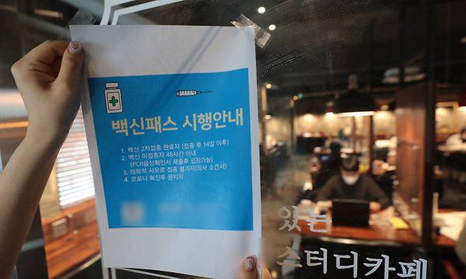 법원이 학원과 독서실, 스터디카페의 방역패스 의무화 효력의 '일시 정지'를 결정한 가운데 지난 5일 서울의 한 스터디카페에서 관계자가 방역패스 관련 안내문을 떼어내고 있다. 뉴스1