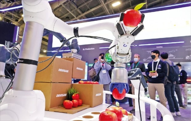 < 사과 따는 로봇 >  두산로보틱스가 개발한 협동로봇이 6일 미국 라스베이거스에서 열린 ‘CES 2022’ 전시장에서 사과를 수확·포장하는 작업을 시연하고 있다.  /라스베이거스=김병언  기자