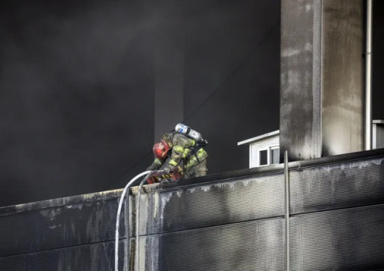 My Colleagues... One firefighter lowers his head as if exhausted, while extinguishing a fire at the cold-storage warehouse in Pyeongtaek-si, Gyeonggi on January 6. Yonhap News