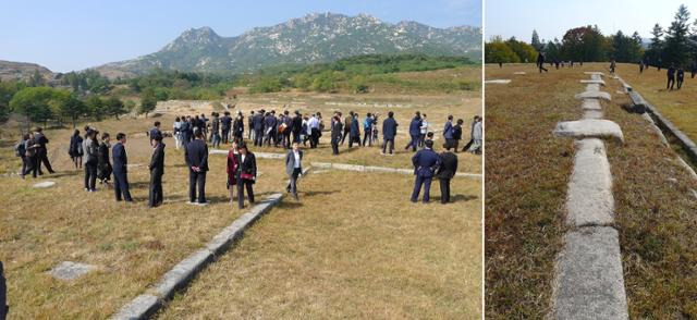 회경전 일대에서 발굴현장에 대한 설명을 듣고 있는 방문단과 회경전 주초석(오른쪽).