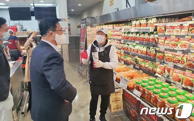 한국농수산식품유통공사 김춘진 사장(가운데)이 21일 미국 H-마트 한국산 김치 판촉 홍보행사장을 점검하고 있다.© 뉴스1