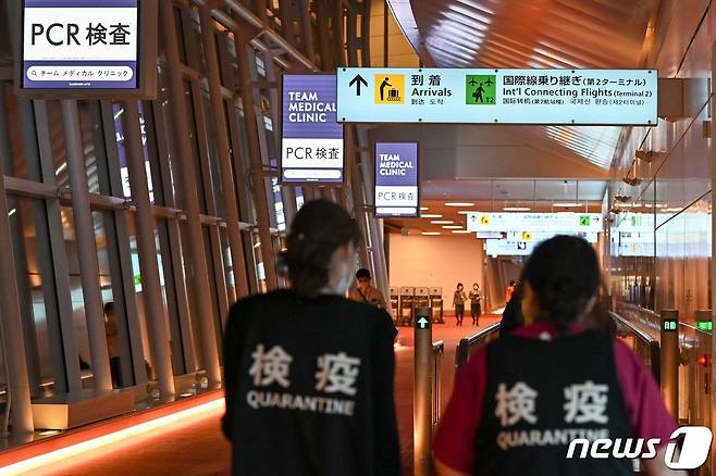일본 도쿄 소재 하네다 공항에서 격리 전담 직원 두명이 국제선 출국장을 향해 걸어가고 있다. 2021.12.01 © AFP=뉴스1