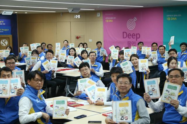 임영진(가운데) 신한카드 사장과 임직원이 2018년 10월 서울 중구 신한카드 본사에서 희귀질환 환아에게 전달할 컬러링 북을 들어 보이고 있다. 신한카드 제공