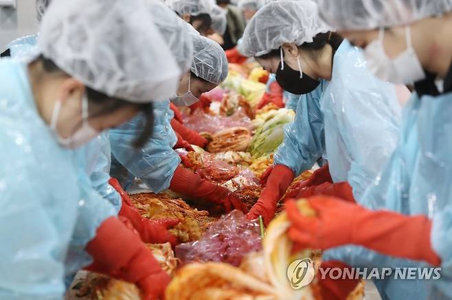 '김장으로 나누는 이웃사랑' (경산=연합뉴스) 김현태 기자 = 지난해 11월 30일 영남대학교 경산캠퍼스 학생회관에서 열린 '2021학년도 제3회 사랑의 김장 나눔' 행사에서 영남대 학생 등 참가자들이 김장하고 있다.  2021.11.30 mtkht@yna.co.kr