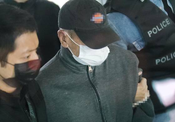 마포 공덕동의 모텔 건물에 불을 지른 혐의로 체포된 A씨가 구속영장심사를 마치고 호송차로 향하고 있다. 연합뉴스