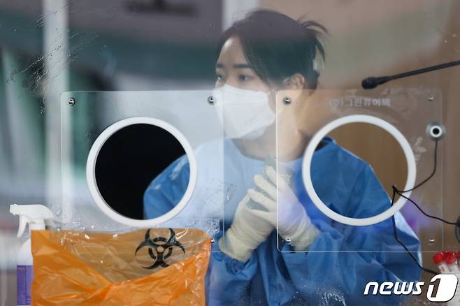 서울 아침기온이 영하 10도로 떨어지는 등 강추위가 찾아온 11일 서울역 광장에 마련된 코로나19 중구 임시선별검사소에서 의료진이 핫팩을 쥐고 있다. 2022.1.11/뉴스1 © News1 안은나 기자