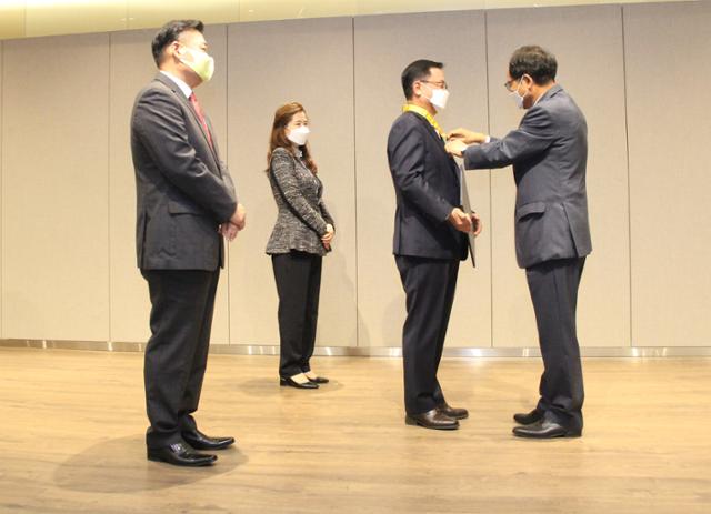 박노완(오른쪽) 주베트남 한국 대사가 지난 5일 한국 대사관에서 열린 국민훈장 수훈식에서 윤상호(오른쪽 두 번째) 전 하노이 한인회장에게 동백장을 수여하고 있다. 하노이 한인회 제공