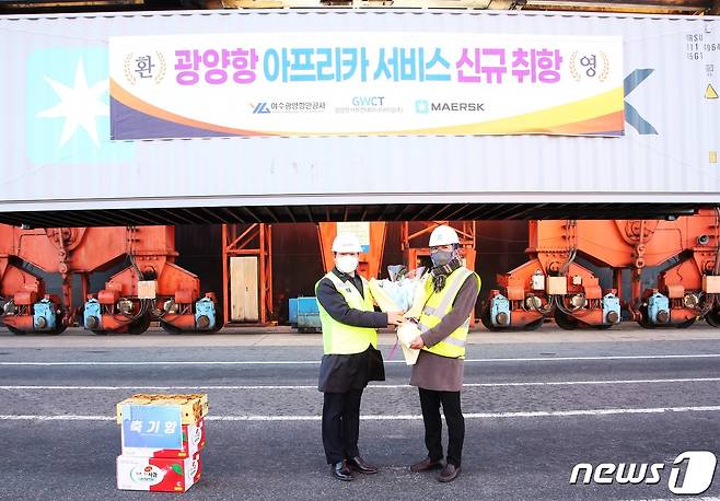 12일 광양항 컨테이너부두에서 진행된 MAERSK IYO호 기항 기념식에서 박성현 사장(사진 왼쪽)이 박정환 MAERSK 광양사무소장에게 꽃다발을 전달하고 있다.(여수광양하악오사 제공)2022.1.12/© 뉴스1