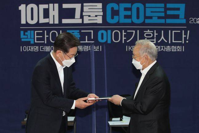 이재명 더불어민주당 대선 후보가 12일 오후 서울 마포구 경총회관에서 열린 10대 그룹 CEO 토크 '넥타이 풀고 이야기합시다'에 참석해 손경식 한국경영자총협회 회장에게 정책건의서를 전달받고 있다. ⓒ데일리안 류영주 기자