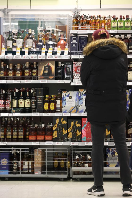 A customer browses in the alcoholic beverage section at a discount mart in Seoul on Wednesday. The imported whiskey market has grown 58 percent since 2019 mainly due to the growth in the number of whiskey drinkers. [YONHAP]