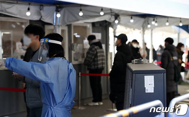 13일 오전 서울 중구 서울역 광장에 마련된 신종 코로나바이러스 감염증(코로나19) 임시 선별검사소에서 관계자가 검사 안내를 하고 있다. 2022.1.13/뉴스1 © News1 이승배 기자