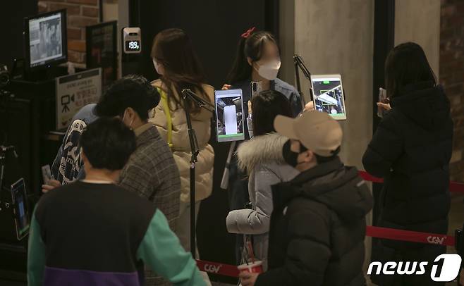 서울 용산구의 한 극장에 QR체크하며 입장하는 관람객들의 모습. 2022.1.2/뉴스1 © News1 김진환 기자