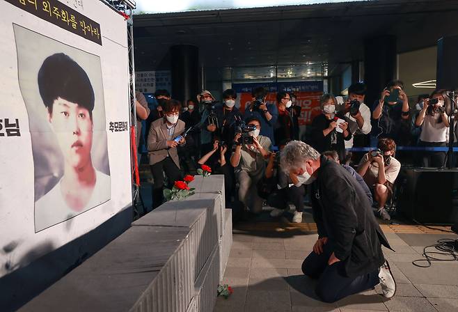 이선호 씨의 부친이 지난해 5월 13일 서울지방고용청 앞에서 열린 추모문화제에서 아들의 얼굴이 새겨진 현수막 앞에 무릎을 꿇고 오열하고 있다. /연합뉴스