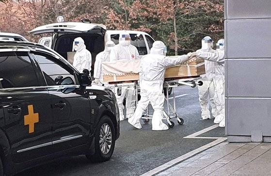 지난해 12월 경기도의 한 화장터에서 레벨D 방호복을 입은 직원들이 코로나19 사망자의 관을 옮기고 있다. [한국장례협회 제공]