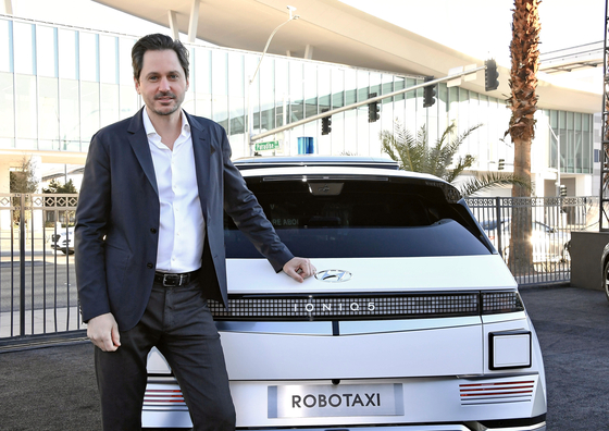Karl Iagnemma, President and CEO of Motional, poses with Ioniq 5-based robotaxi on Jan. 6 at CES 2022 in Las Vegas. [HYUNDAI MOTOR]