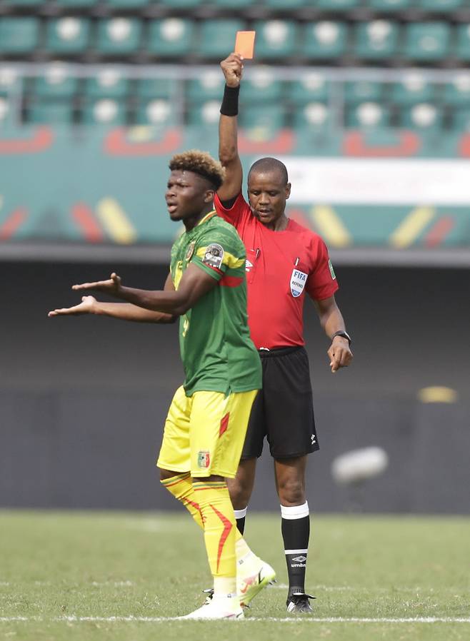 Referee Janny Sikazwe of Zambia, right, shows Mali‘s El Bilal Toure a red card during the African Cup of Nations 2022 group F soccer match between Tunisia and Mali at the Limbe Omnisport Stadium in Limbe, Cameroon, Wednesday, Jan. 12, 2022. AP연합뉴스