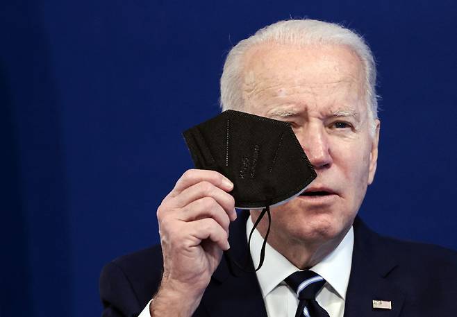 US President Joe Biden holds a mask on Jan. 13 in Washington, DC. as he gives remarks on his administration`s plan to make "high-quality masks" available to Americans for free. AFP-Yonhap