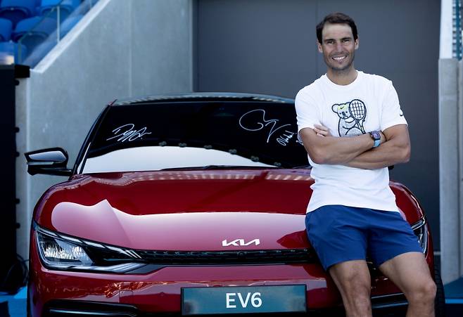 테니스 선수 라파엘 나달이 기아 전기차 EV6 앞에서 기념 사진을 촬영하고 있다./사진제공=기아