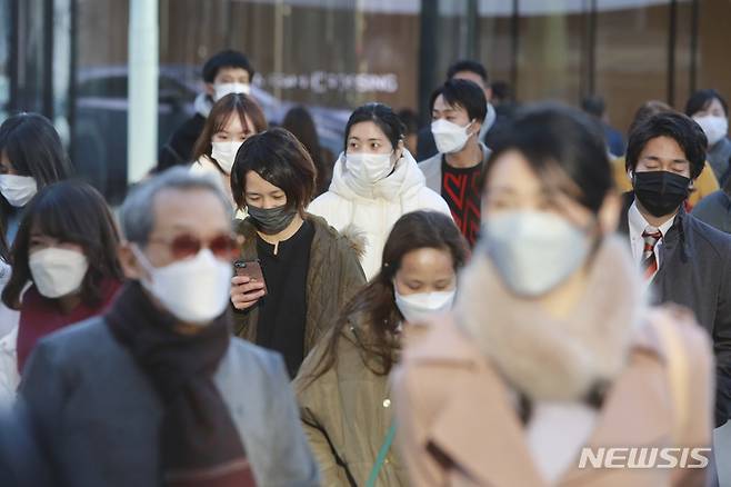 [도쿄(일본)=AP/뉴시스]지난 12일 일본 도쿄의 거리를 코로나19 감염 예방을 위해 마스크를 착용한 시민들이 걸어가고 있다. 2022.01.14.