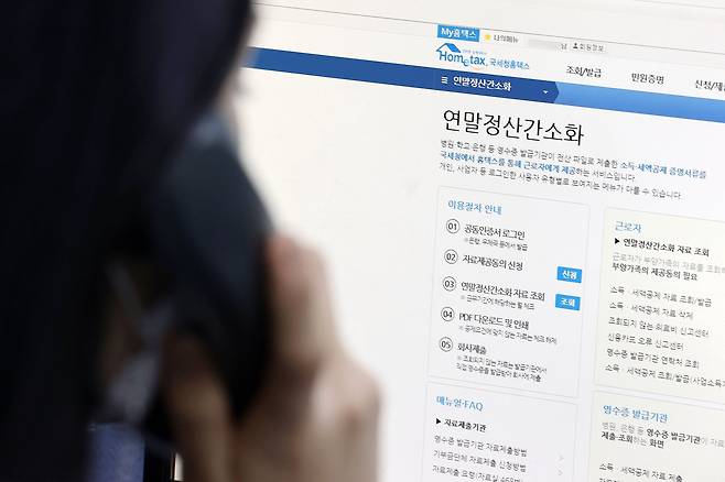 연말정산 소득·세액공제에 필요한 증명자료를 조회할 수 있는 홈택스 연말정산 간소화 서비스가 개통된 15일 오후 서울 종로세무서에서 한 직원이 홈택스 홈페이지를 살피며 문의 전화를 받고 있다. [연합뉴스]