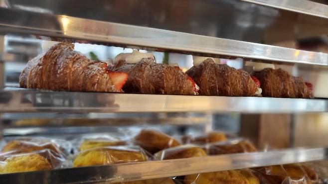 Baked croissants are lined up in trays, ready to be served to customers. (Kim Hae-yeon/ The Korea Herald)