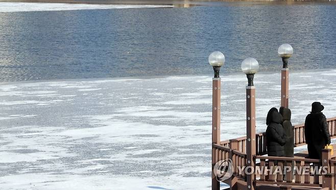 한파에 얼어붙은 연제저수지 (청주=연합뉴스) 천경환 기자 = 12일 오후 시민들이 꽁꽁 얼어붙은 청주시 흥덕구 연제저수지를 바라보고 있다. 2022.1.12 kw@yna.co.kr