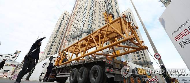 옮겨지는 해체 크레인 부품 (광주=연합뉴스) 김도훈 기자 = 광주 서구 화정동 신축아파트 붕괴사고 닷새째인 15일 오전 사고 현장에서 관계자들이 해체크레인 부품들을 옮기고 있다. 2022.1.15 superdoo82@yna.co.kr