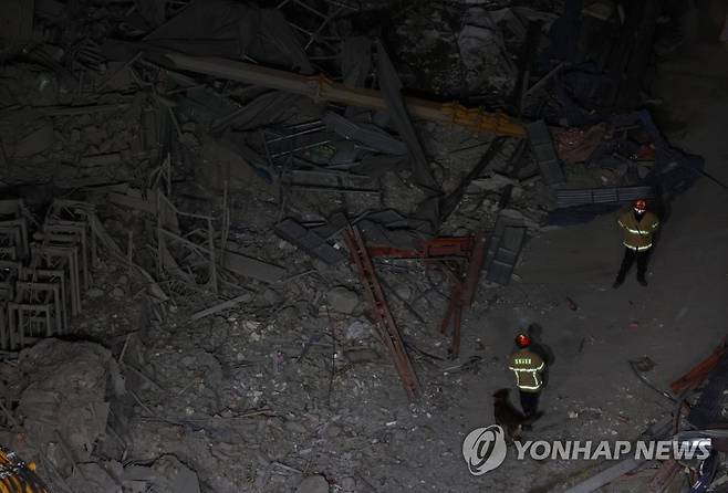 멈출 수 없는 야간 수색 작업 (광주=연합뉴스) 김도훈 기자 = 광주 서구 화정동 신축아파트 붕괴사고 닷새째인 15일 저녁 대원들이 구조견과 함께 현장을 수색 작업을 하고 있다. 2022.1.15 superdoo82@yna.co.kr
