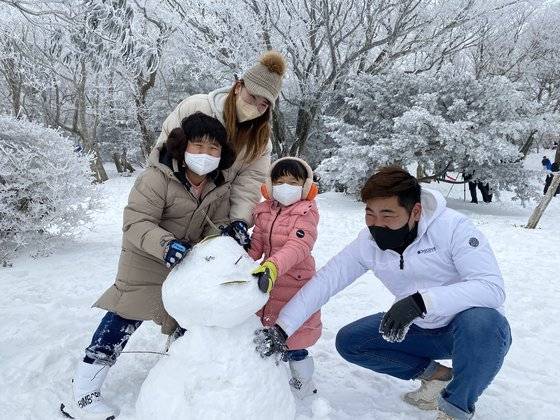 지난 12일 오후 제주 한라산 1100고지를 찾은 가족단위 탐방객들이 눈사람을 만들고 있다. 최충일 기자
