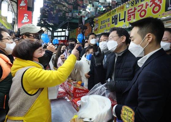 이재명 더불어민주당 대선후보가 16일 강원도 강릉시 중앙시장을 방문, 닭강정을 사고 있다. 연합뉴스