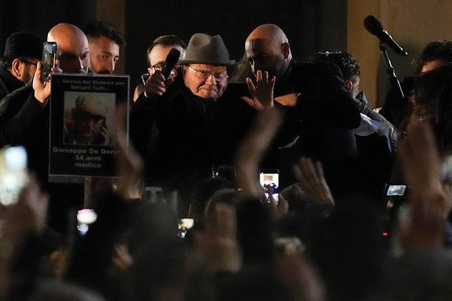 프랑스 바이러스 학자인&nbsp;뤼크 몽타니에(가운데)가 15일(현지시간) 이탈리아 밀라노에서 열린 ‘그린 패스’ 반대 시위에서 연설한 뒤&nbsp;시위대를 향해 손을 흔들고 있다.&nbsp;밀라노=AP연합뉴스