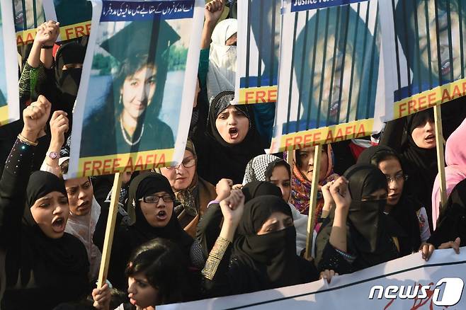 파키스탄 시위대가 2014년 11월 15일(현지시간) 라호르에서 아피아 시디키의 사진을 들면서 그의 석방을 요구하고 있다. © AFP=뉴스1 © News1 김지현 기자