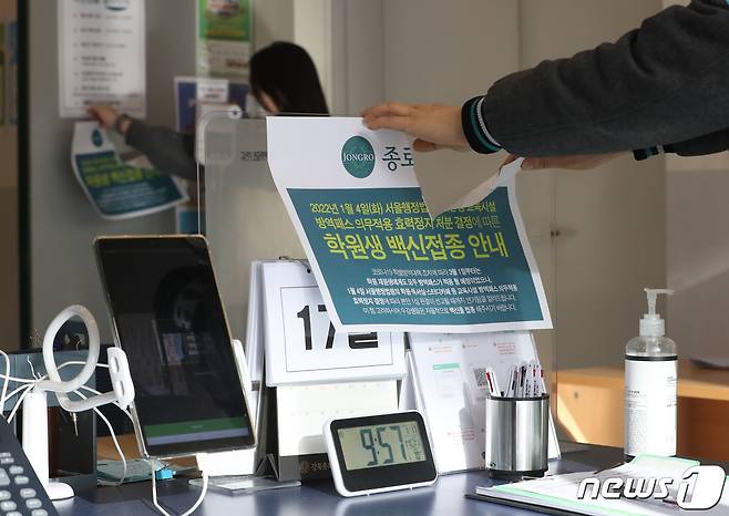 정부가 보습학원·독서실·박물관·영화관·대형마트 등의 방역패스 적용을 해제한다고 밝힌 17일 서울 마포구 종로학원 강북본원에서 관계자들이 방역패스 안내문을 떼고 있다. 2022.1.17/뉴스1 © News1 이성철 기자